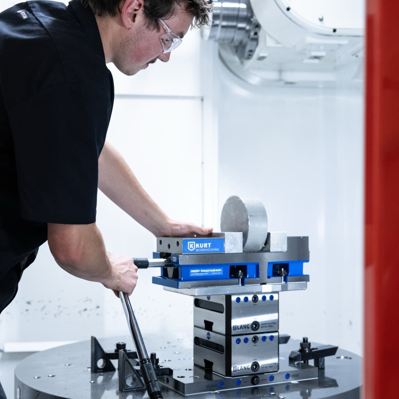 An intern sets a part in a vise on a mill's rotary table