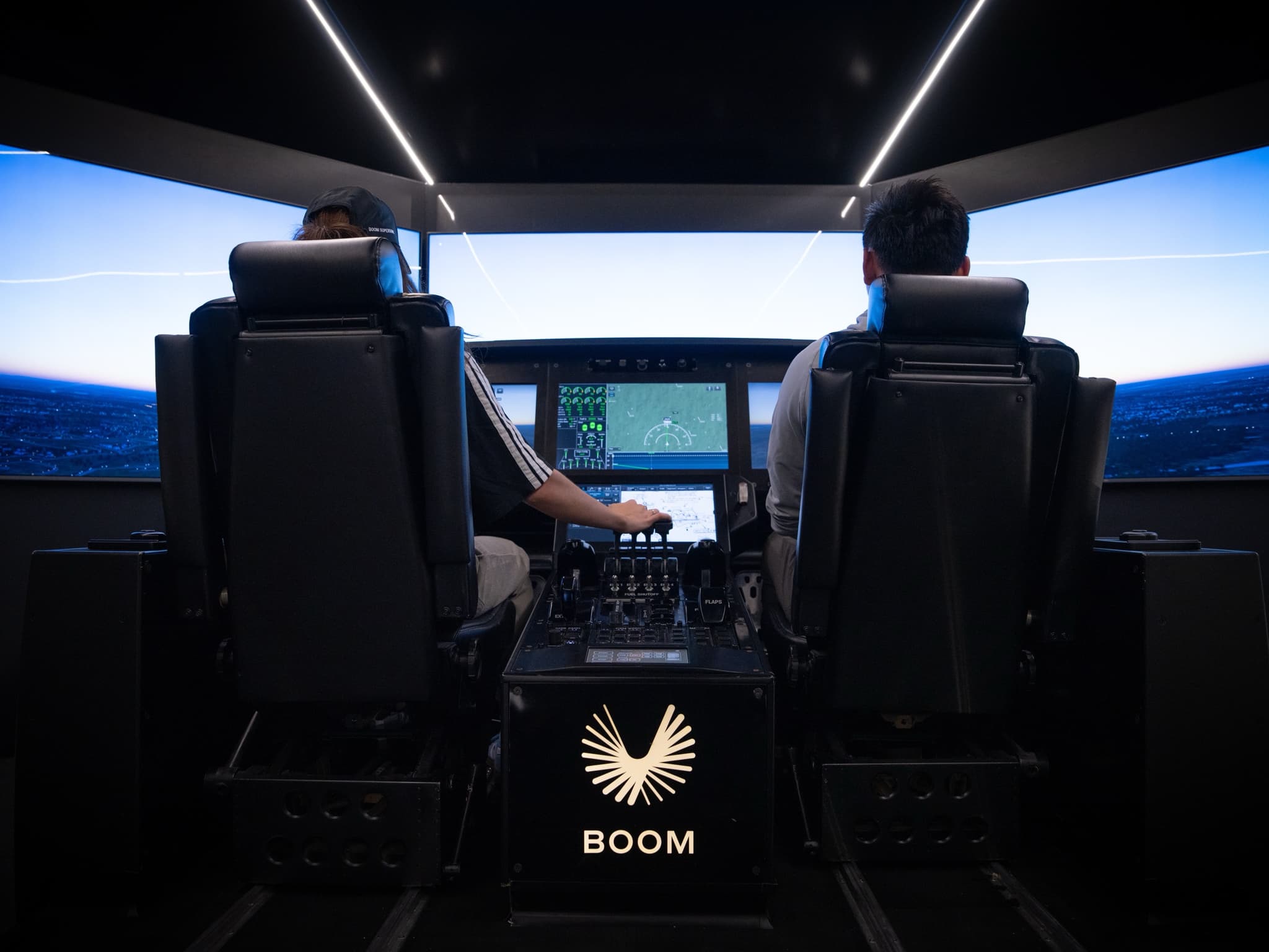 Side by side at the controls of the Overture flight deck simulator