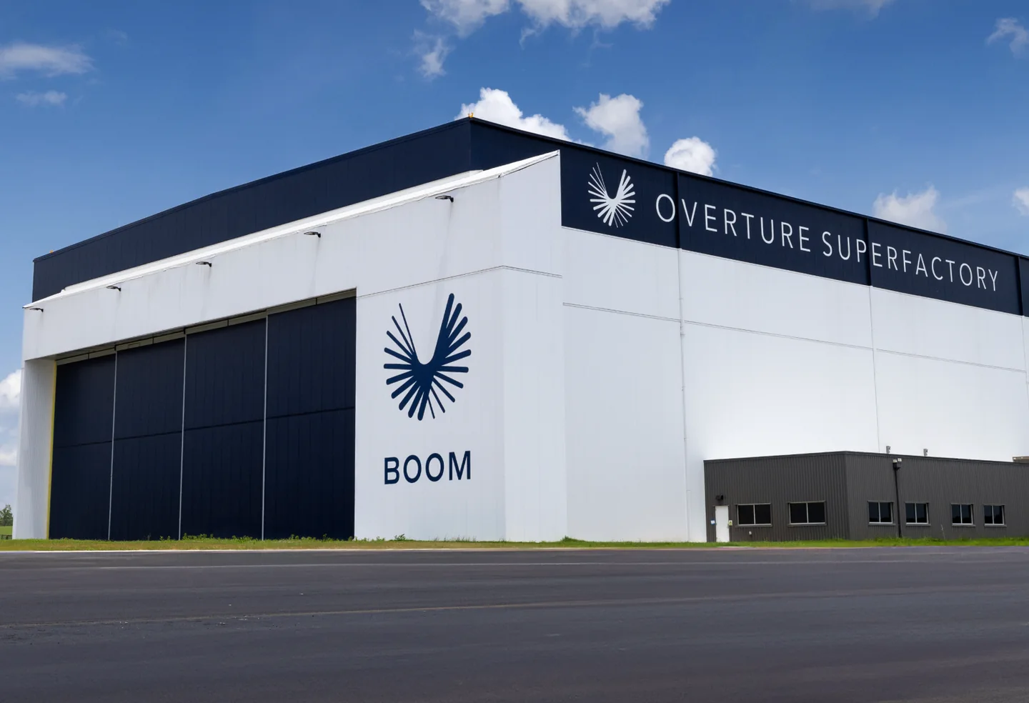 The Overture Superfactory hangar in Greensboro, North Carolina, with the Boom logo on its side