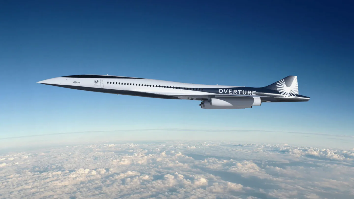 Overture, Boom's sustainable supersonic airliner, built for speed, safety, and sustainability, in flight over the clouds.