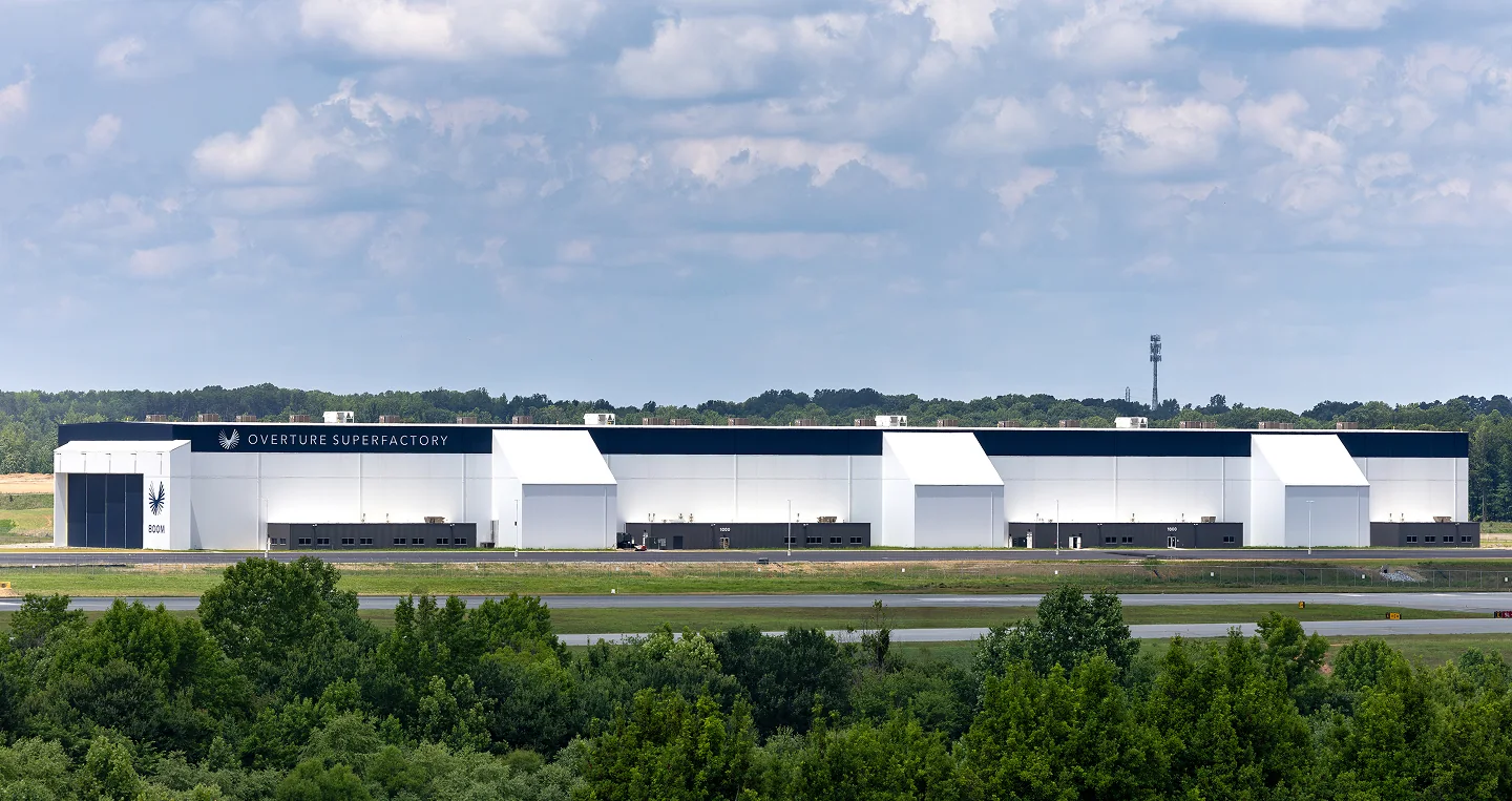 The completed Overture Superfactory in Greensboro, North Carolina, beyond a line of trees