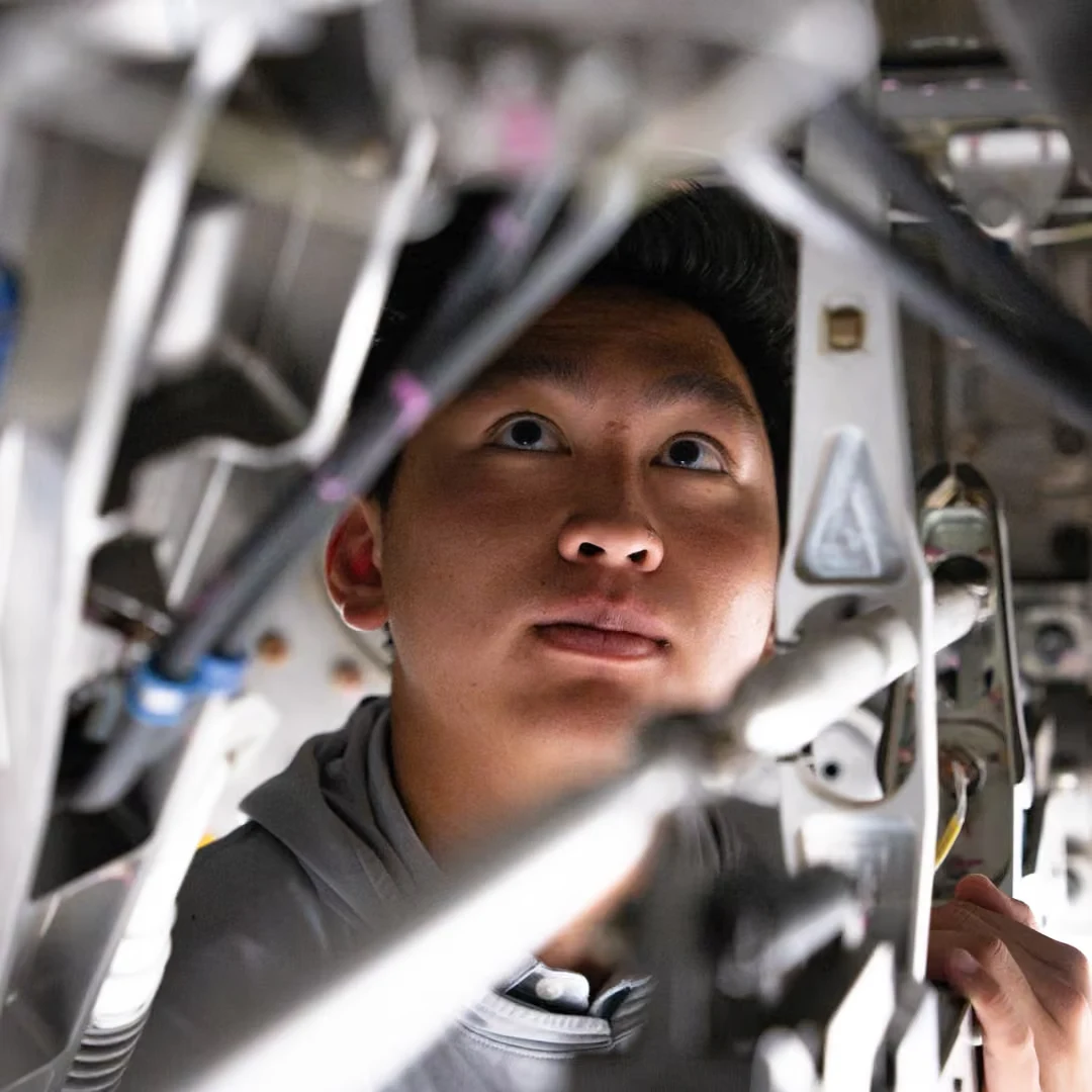 A Boom technician looking up into the assembly overhead