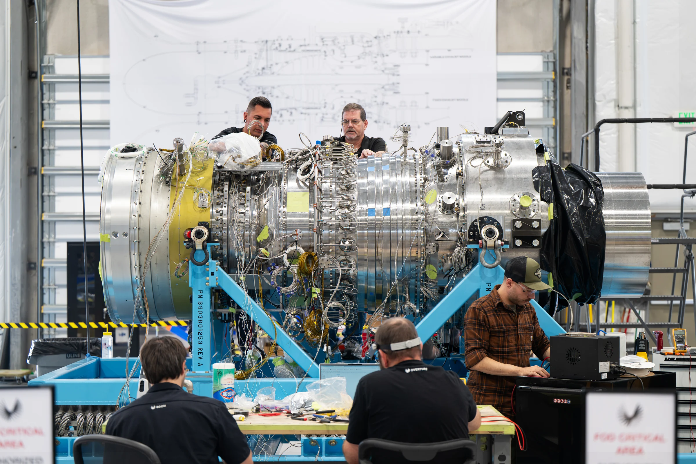 The Superpower team assembling a turbine on a blue stand in the workshop