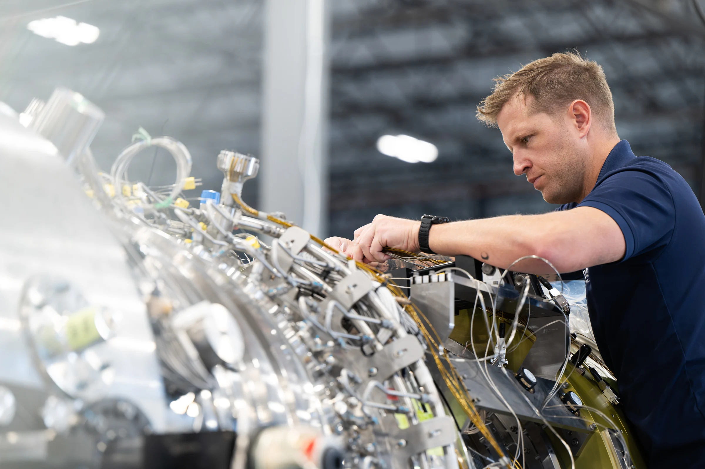 A technician inspecting the turbine's pipework and instrumentation