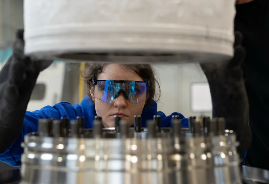 A Boom technician lowering a component onto the test rig