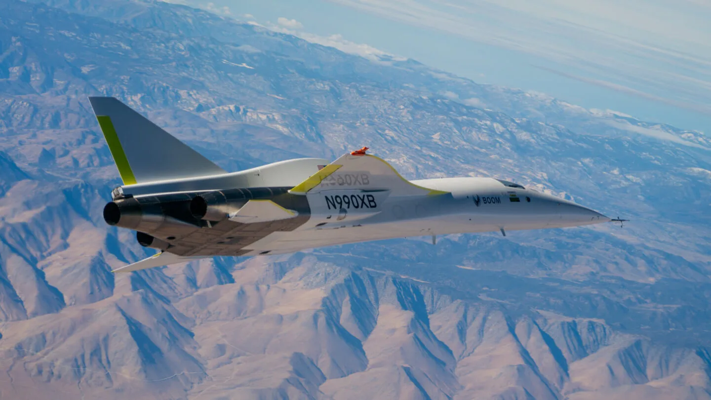 XB-1 flying above desert mountains, seen from below its left side